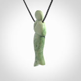 Hand carved New Zealand Jade woman drop pendant. Made by Ana Krakosky for NZ Pacific in New Zealand Pounamu, jade. A beautiful light green jade figure of a woman, drop necklace with black adjustable cord.